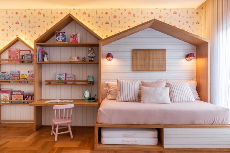 Quarto infantil com cama em formato de casinha, escrivaninha e nichos