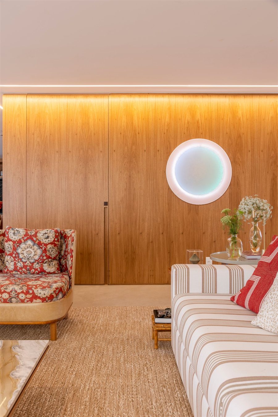 Painel de madeira com porta oculta e iluminação embutida em sala de estar